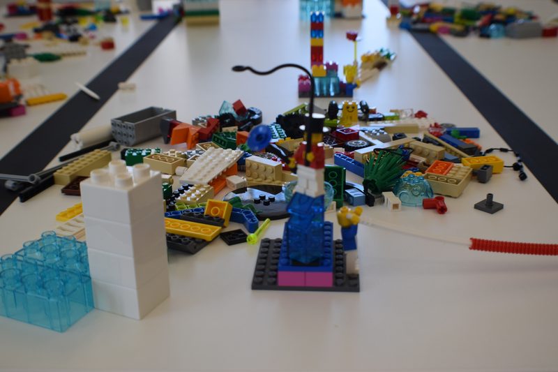 A table mid-workshop, models and loose bricks spread across it